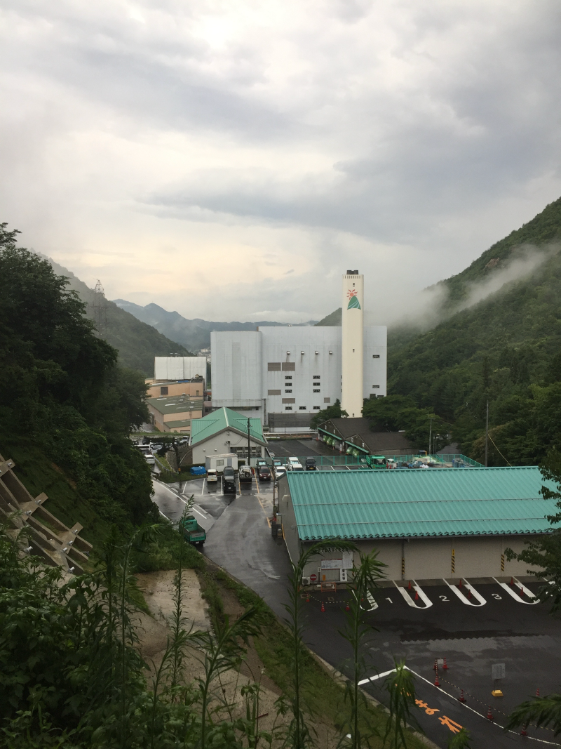 Industrial facility in mountain valley with mist rising after storm