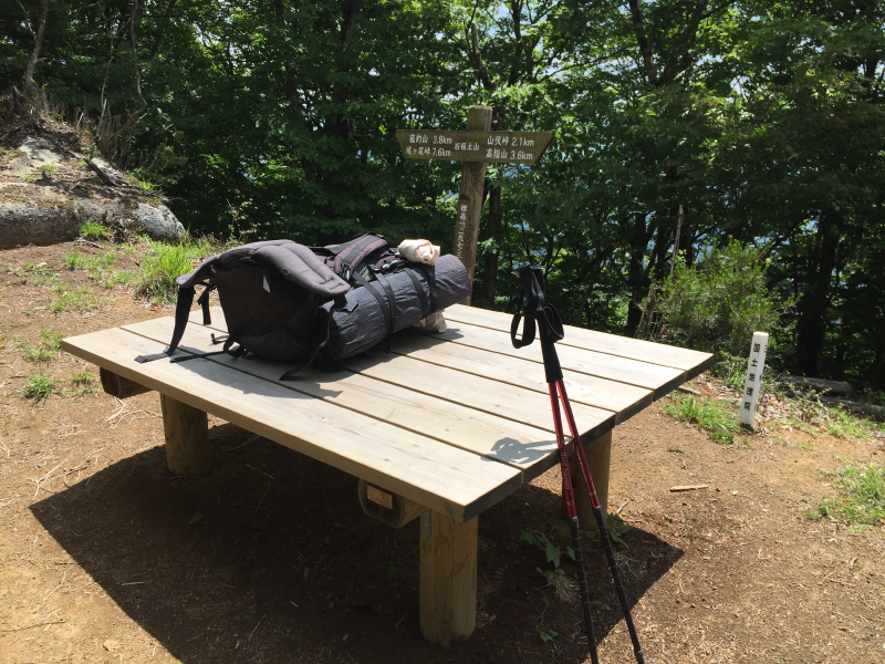 Backpack and hiking poles on summit table