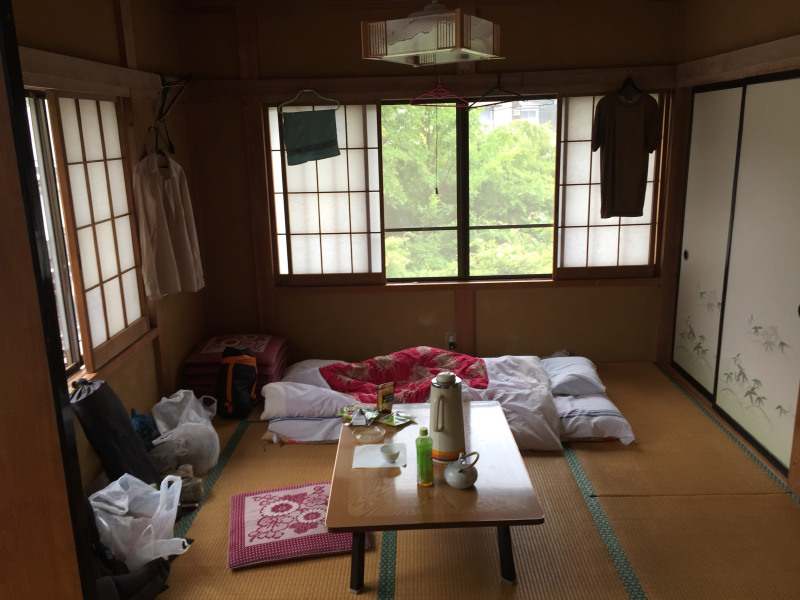Traditional Japanese room with futon bedding and hiking gear