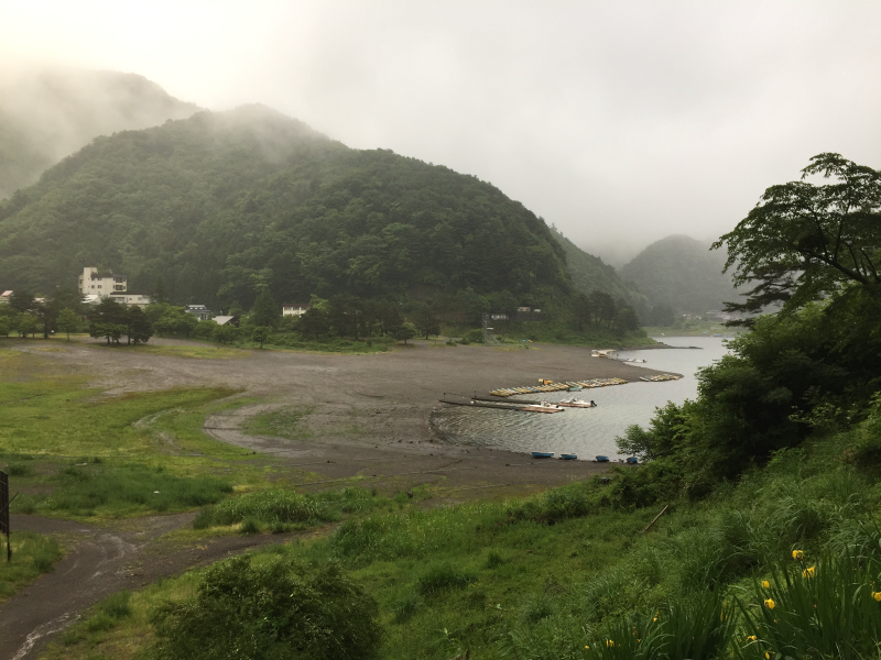 Lake shore with boat dock and cloudy mountains