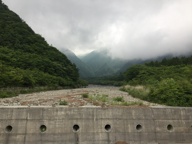 Dry riverbed with misty mountains in distance