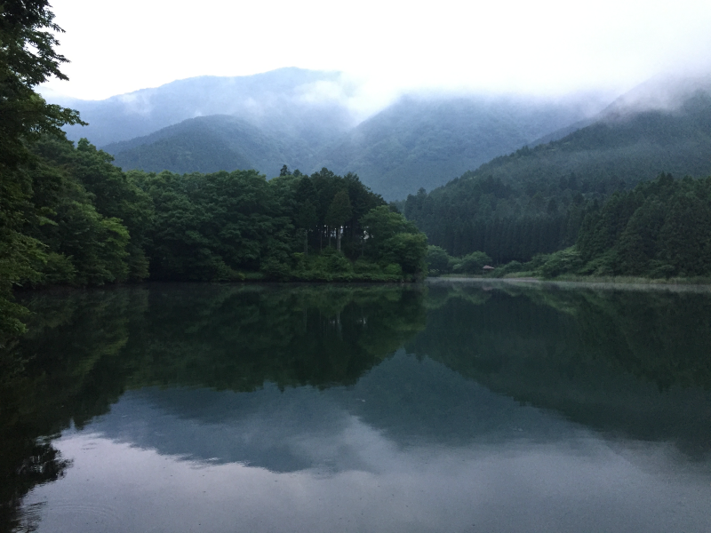 Lake with trees and mountains reflected in still water