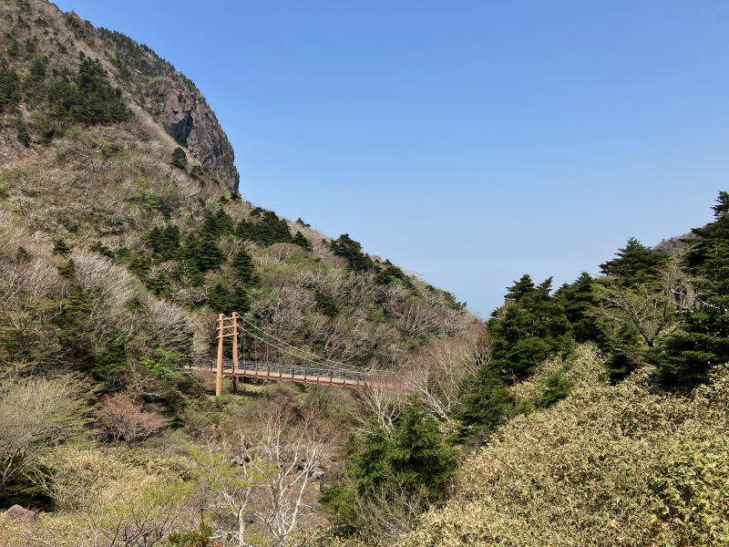 Small suspension bridge between rocky cliffs in valley